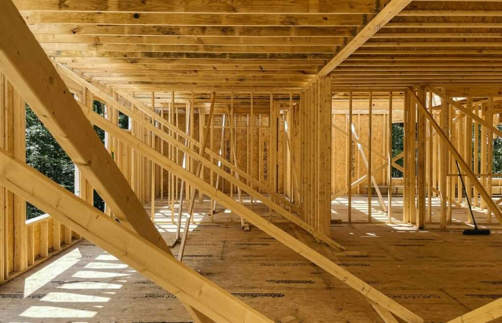 Interior of a wooden framing construction with studs, beams, and diagonal braces forming a skeleton of a house under construction (pine framing).