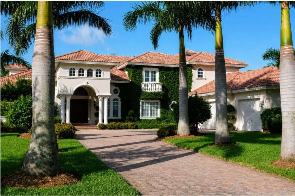 Luxury custom Mediterranean-style home with palm-lined driveway in South Florida