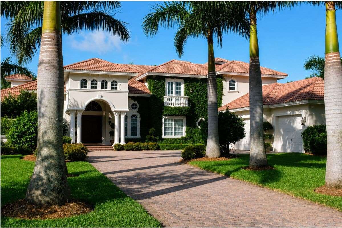 Luxury custom Mediterranean-style home with palm-lined driveway in South Florida