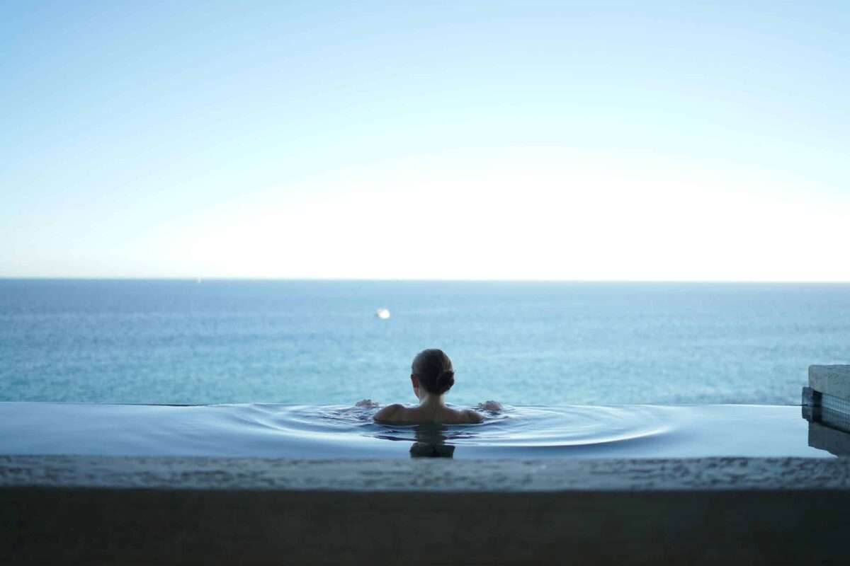 Luxury infinity pool overlooking the ocean, showcasing a serene outdoor living space that complements a custom luxury home.