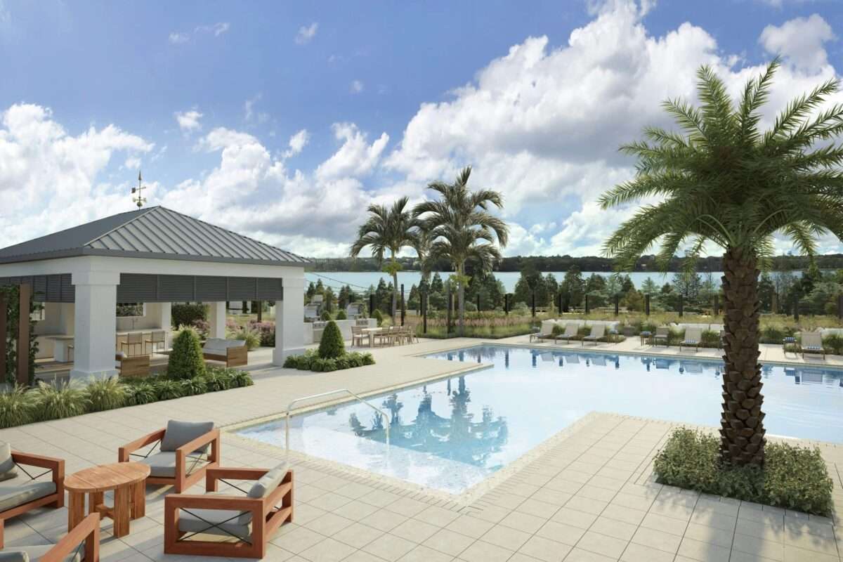 Luxury custom home outdoor entertainment area featuring a resort style swimming pool, covered pavilion, outdoor kitchen, palm trees, and stunning ocean views.