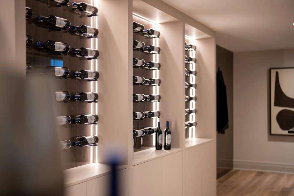 Modern luxury home wine display featuring custom illuminated wine storage, built in cabinetry, and elegant contemporary design.