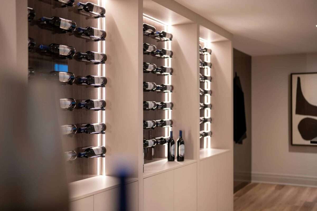Modern luxury home wine display featuring custom illuminated wine storage, built in cabinetry, and elegant contemporary design.