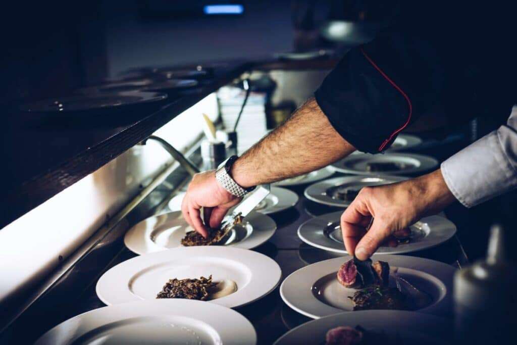 Private chef plating dishes in a luxury home catering kitchen