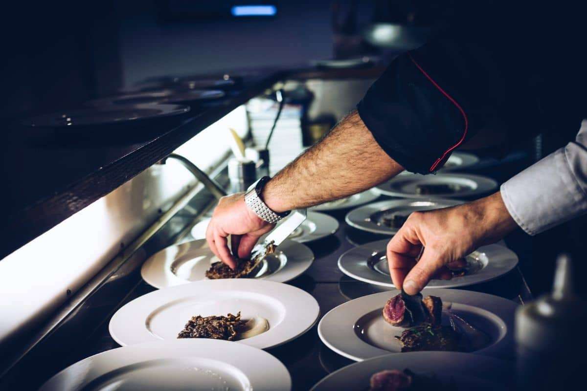 Private chef plating dishes in a luxury home catering kitchen