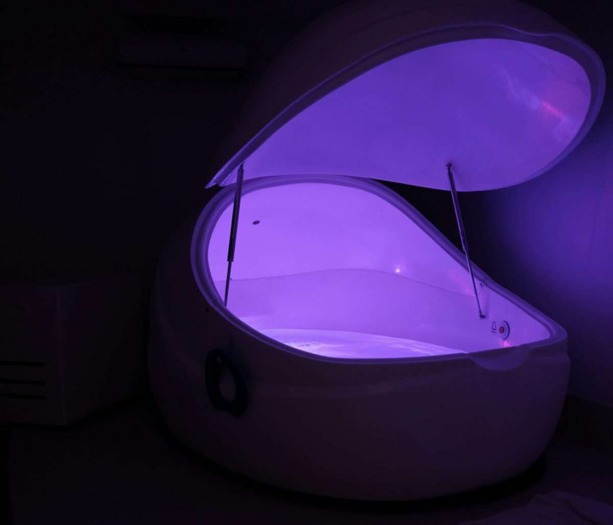Flotation therapy tank with ambient lighting in a private wellness space