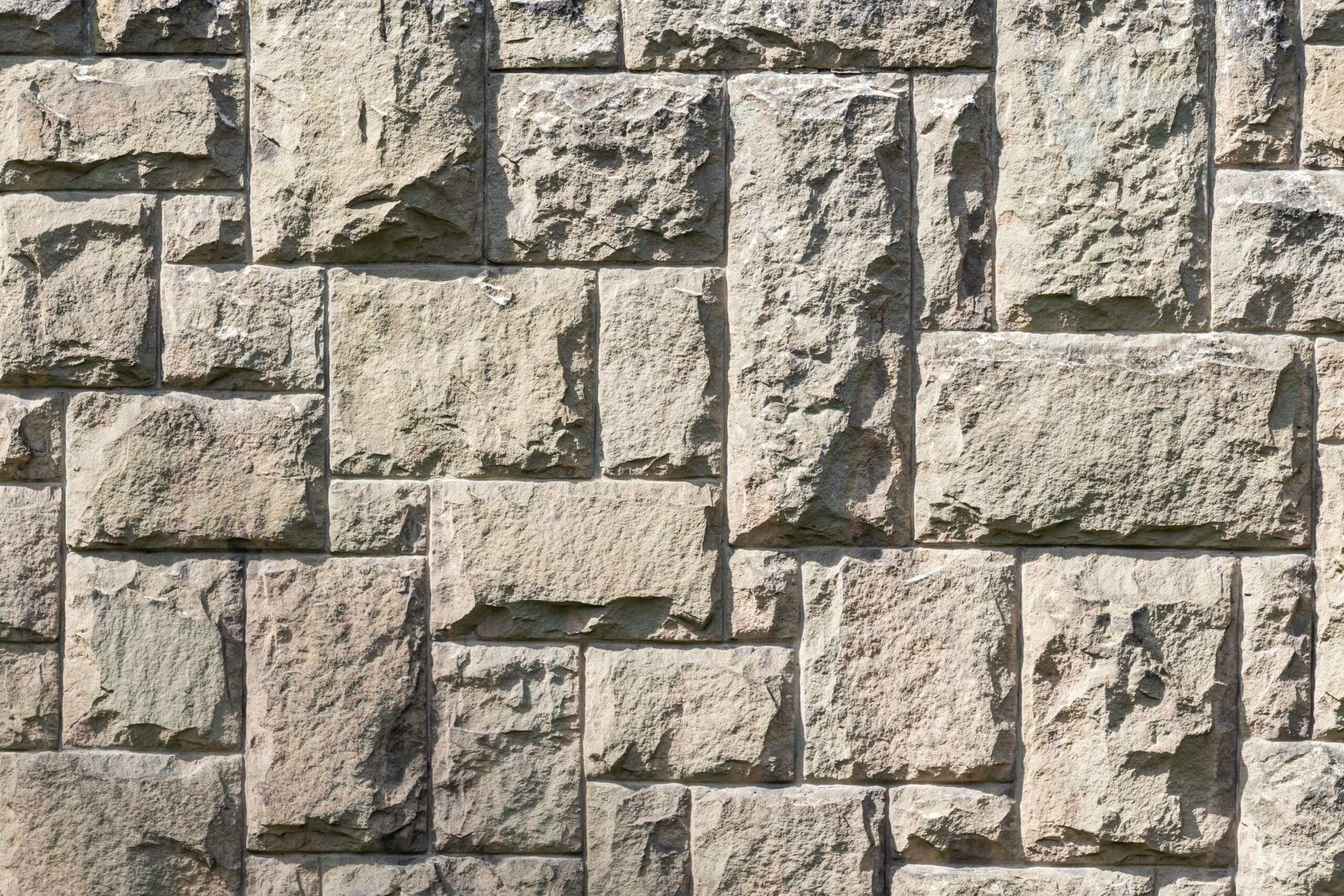 Natural stone wall detail showing varied textures and masonry craftsmanship used in luxury home construction