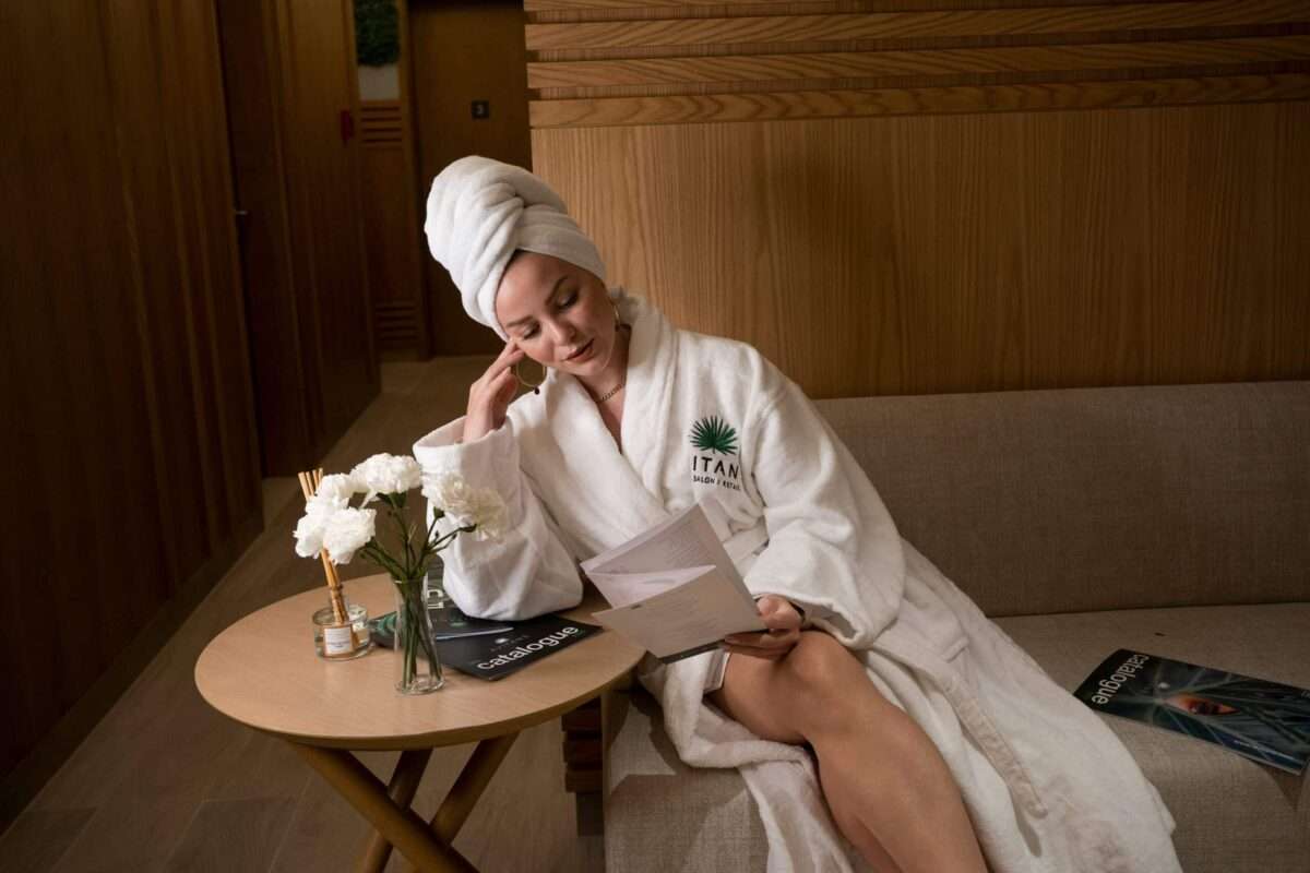 Woman relaxing in a luxury spa lounge wearing a robe