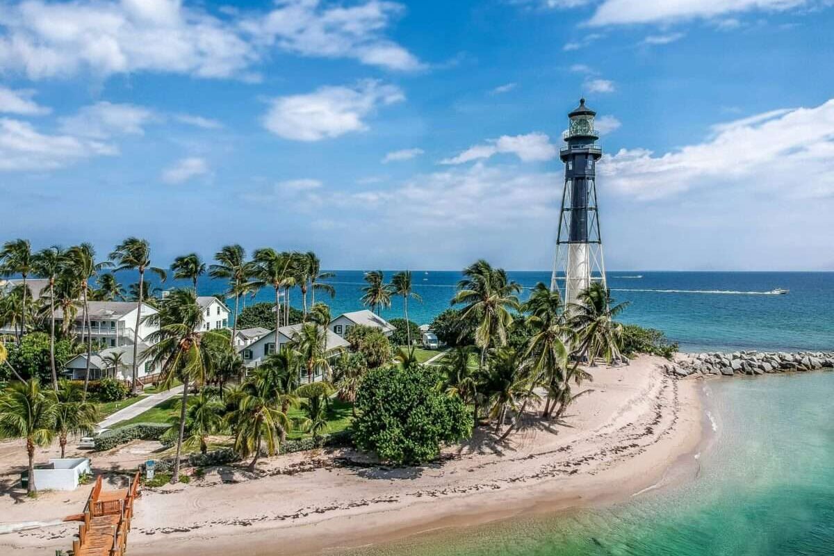 Hillsboro Inlet Lighthouse surrounded by palm trees beside the ocean near Pompano Beach, Florida